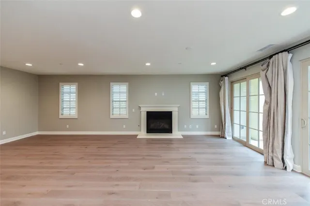 an empty room with windows and fireplace