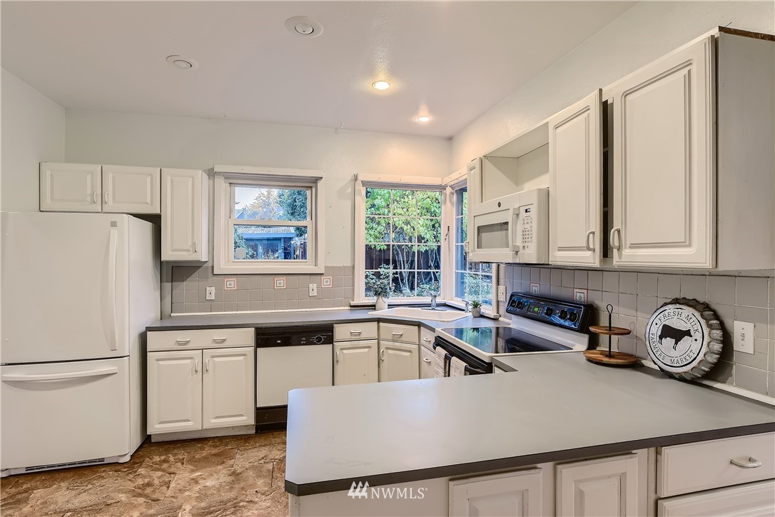 10308 Northeast 186th Street Bothell, WA 98011 - Photo 8 of 25 a kitchen with stainless steel appliances granite countertop a sink a stove and refrigerator