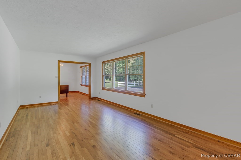 35 Powhatan Road Kilmarnock, VA 22482 - Photo 9 of 42 Spare room featuring baseboards, light wood finished floors, and visible vents