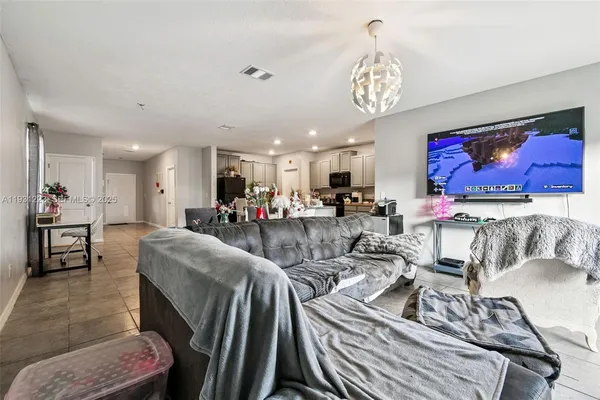 a living room with furniture a chandelier and a dining table