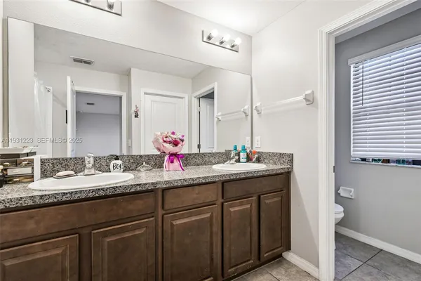 a bathroom with a granite countertop sink double and mirror