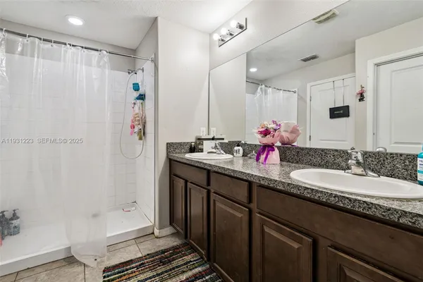a bathroom with double vanity and a shower