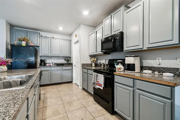 a kitchen with granite countertop a sink stainless steel appliances and cabinets