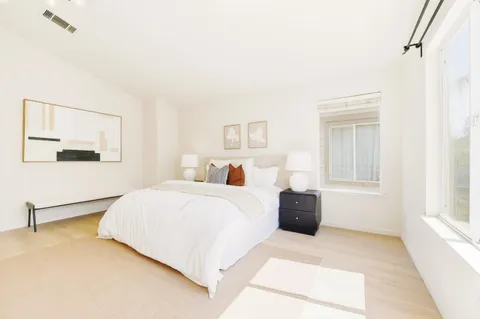 a bedroom with a bed lamp and a window