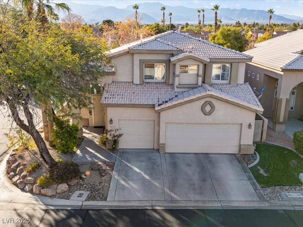 5505 Big Sky Lane Las Vegas, NV 89149 - Photo 15 of 42 View of front of house featuring an attached garage, a tiled roof, concrete driveway, stucco siding, and a mountain view