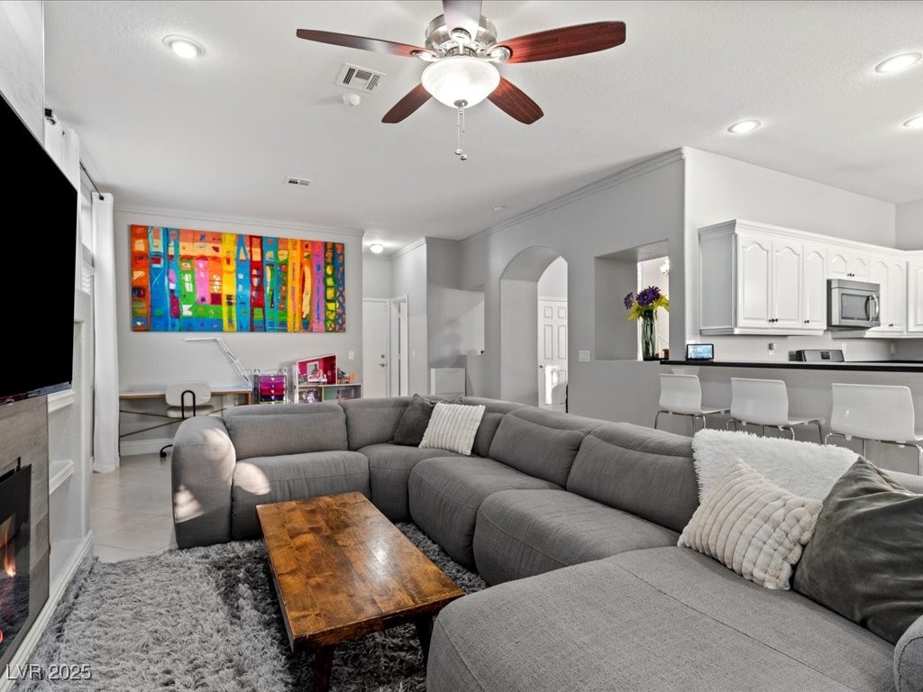 5505 Big Sky Lane Las Vegas, NV 89149 - Photo 32 of 42 Living area with visible vents, ceiling fan, ornamental molding, light tile patterned flooring, and arched walkways