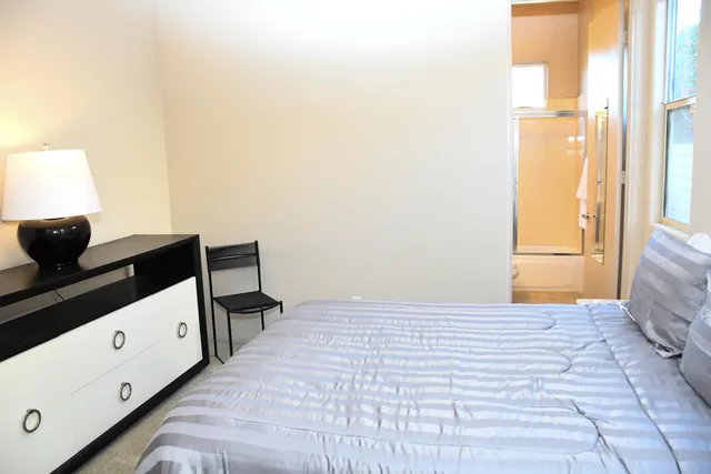 a bedroom with a bed and a night stand