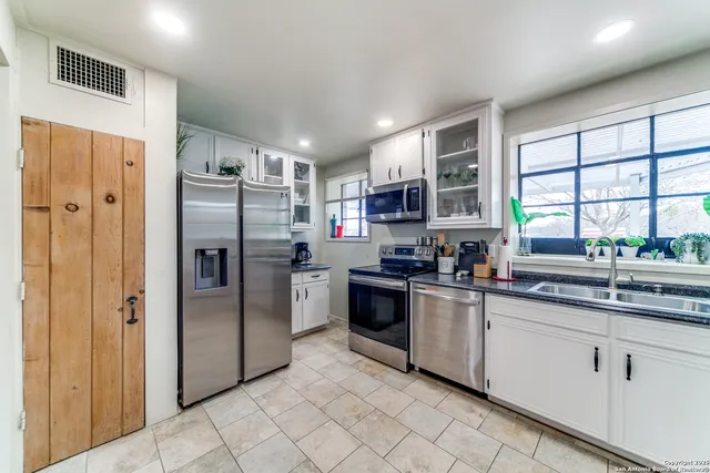 a kitchen with cabinets and refrigerator