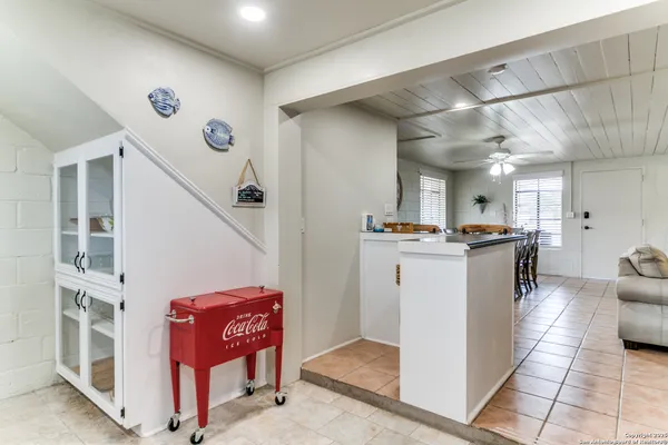 a bedroom with a bed a dresser and windows