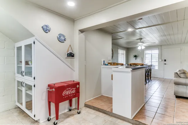 a bedroom with a bed a dresser and windows