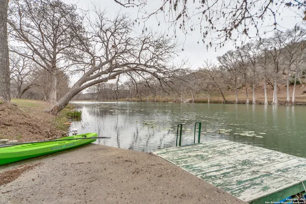 a backyard of a house with lots of green space and lake view