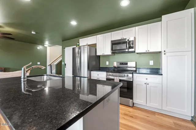 a kitchen with granite countertop a sink stove and cabinets