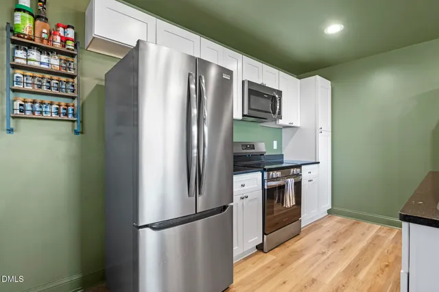 a kitchen with stainless steel appliances granite countertop a refrigerator a stove a sink and a refrigerator