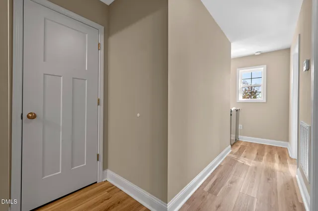 a view of a hallway with wooden floor and staircase