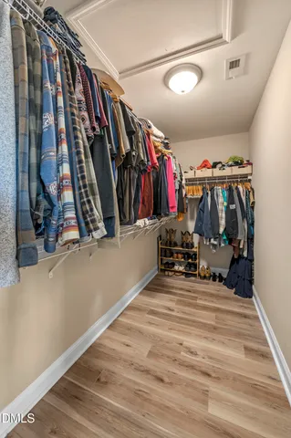 a bedroom with a large bed and a large window with wooden floor