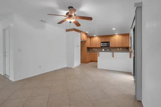 a kitchen with stainless steel appliances granite countertop a sink a stove top oven a chimney and a refrigerator