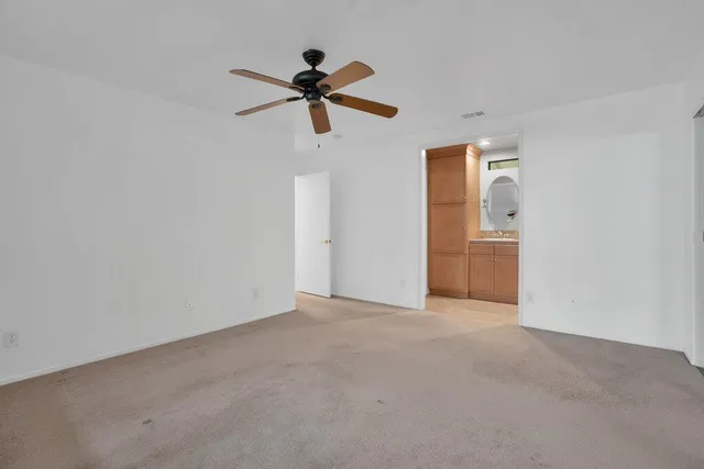 a view of a room with a ceiling fan and a ceiling fan