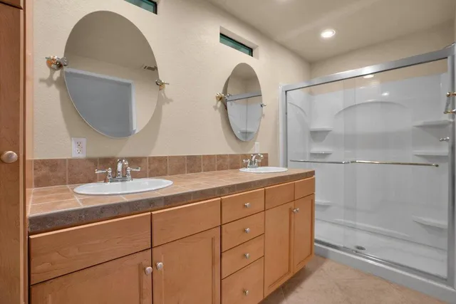 a bathroom with a double vanity sink and a mirror