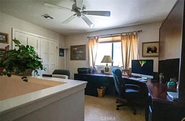 a view of a workspace with furniture and a window