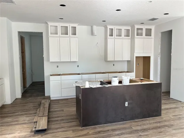 a living room with stainless steel appliances kitchen island wooden cabinets and entryway
