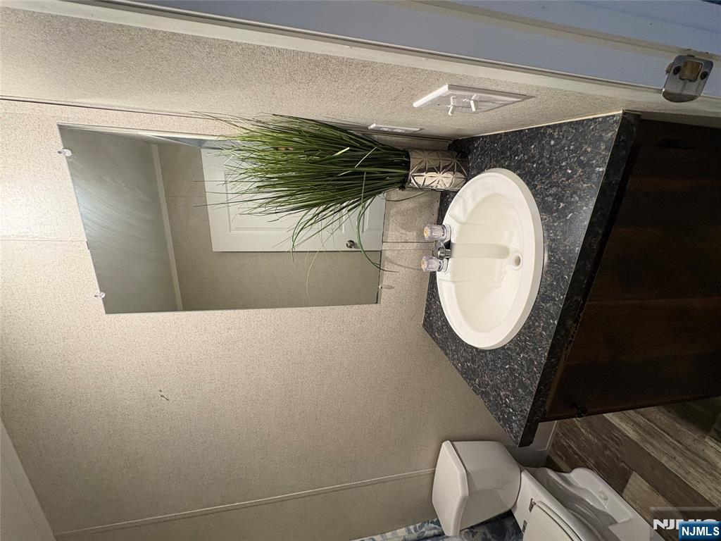131 Elm Street Lodi, NJ 07644 - Photo 16 of 18 a bathroom with a granite countertop sink and a mirror