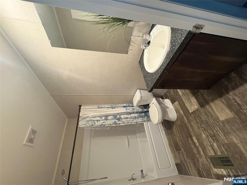 131 Elm Street Lodi, NJ 07644 - Photo 5 of 18 a bathroom with a sink a toilet and shower