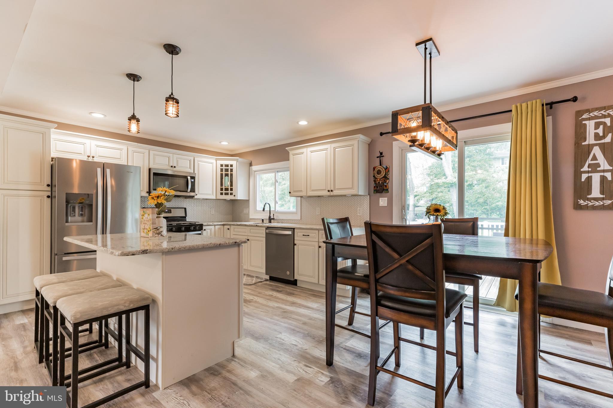 255 Winding Way Road Stratford, NJ 08084 - Photo 11 of 31 a kitchen with kitchen island a dining table chairs and white cabinets