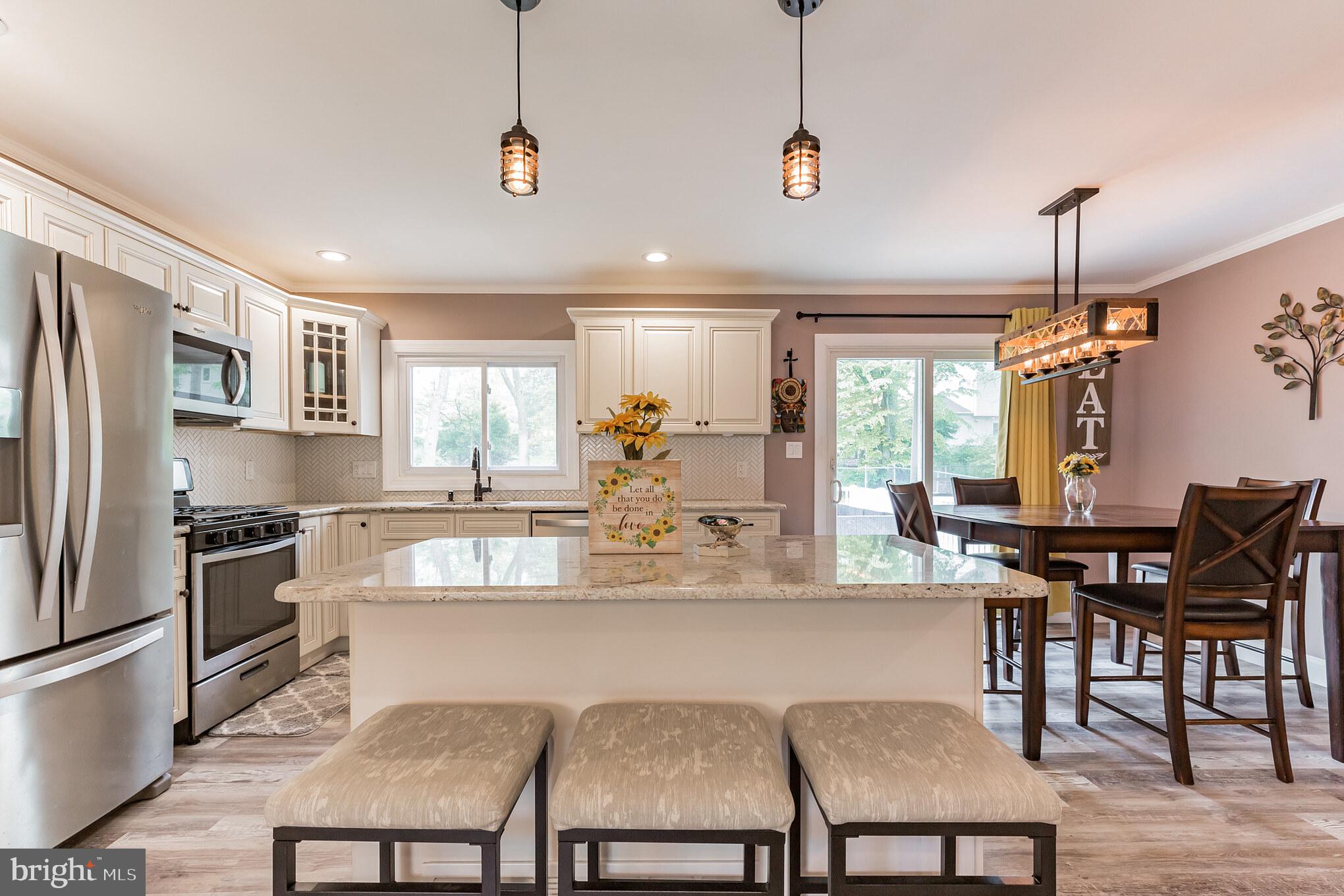 255 Winding Way Road Stratford, NJ 08084 - Photo 14 of 31 a dining room with stainless steel appliances granite countertop a dining table chairs refrigerator and cabinets