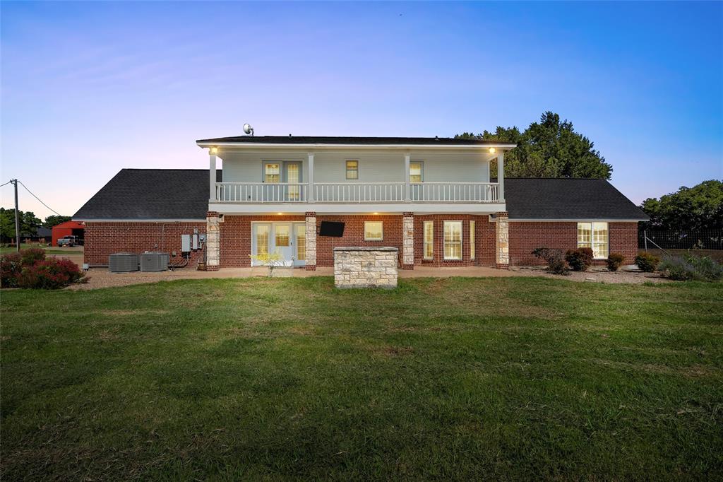 5112 Old Caufield Ranch Road McGregor, TX 76657 - Photo 30 of 38 Rear view of house featuring a patio, a balcony, a lawn, and brick siding