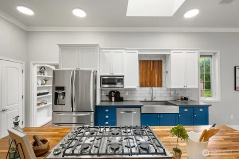 a kitchen with stainless steel appliances a stove a sink and a refrigerator