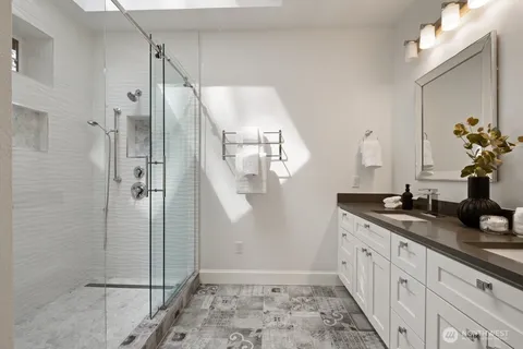 a bathroom with a granite countertop sink mirror and shower