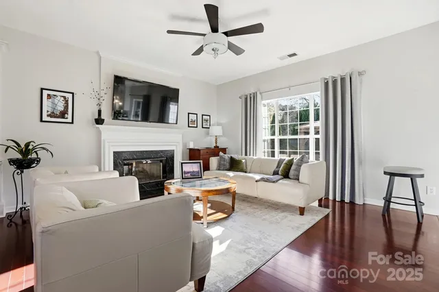 a living room with furniture a fireplace and a flat screen tv