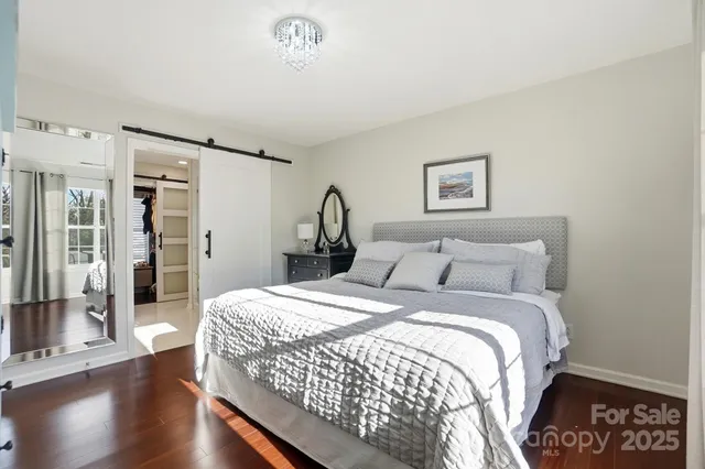 a bedroom with a large bed and a chandelier