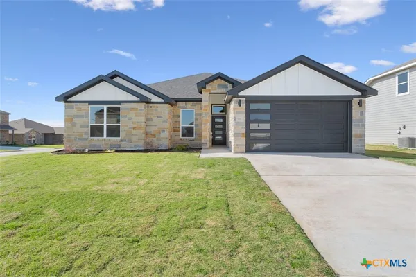 a front view of house with yard and garage