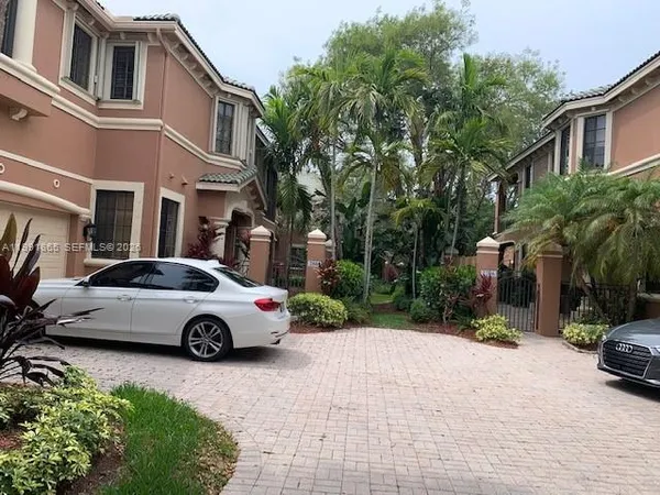 a front view of a house with a yard and potted plants