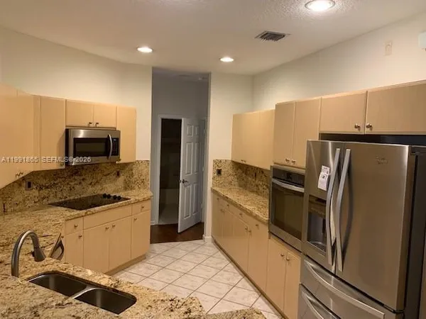 a kitchen with stainless steel appliances granite countertop a sink stove and cabinets