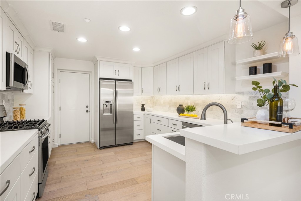 268 Lockford Irvine, CA 92602 - Photo 2 of 5 a kitchen with stainless steel appliances granite countertop a refrigerator a sink a stove a dining table and chairs with wooden floor