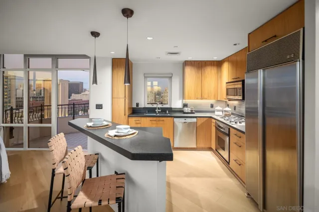 a kitchen with stainless steel appliances granite countertop a sink a stove and a refrigerator