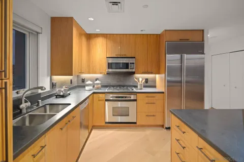 a kitchen with stainless steel appliances granite countertop a sink stove and refrigerator