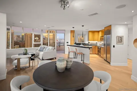 a living room with stainless steel appliances furniture a dining table and chairs