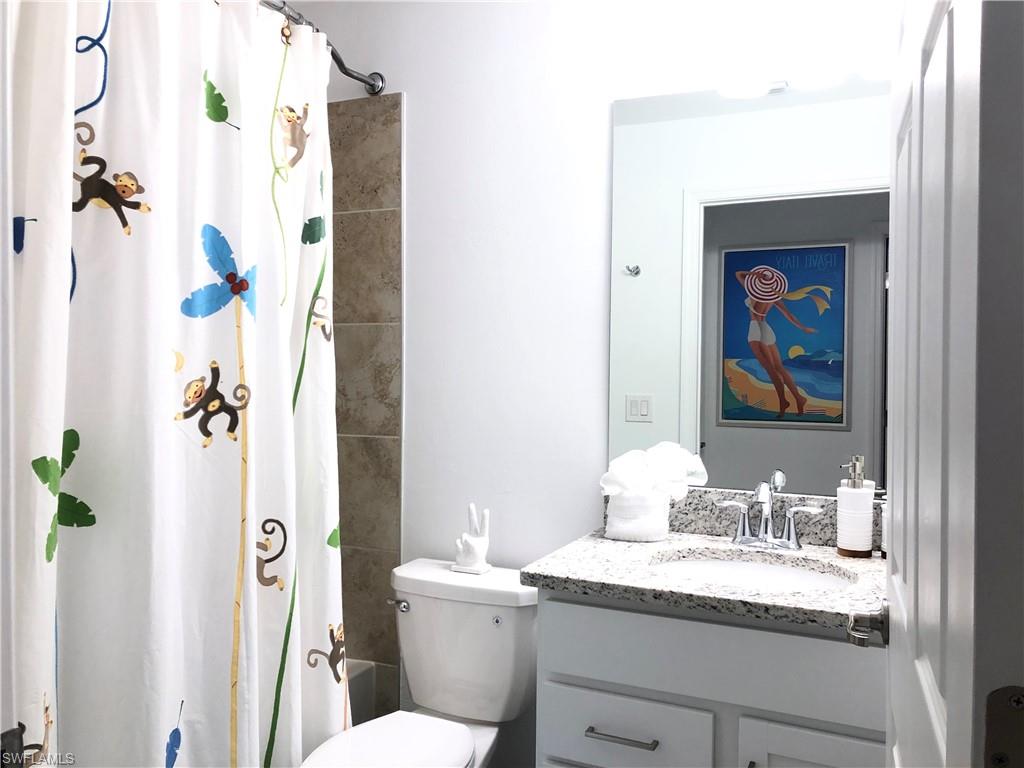 43031 Greenway Boulevard, Unit 1014 Babcock Ranch, FL 33982 - Photo 11 of 19 a bathroom with a granite countertop sink a toilet and shower
