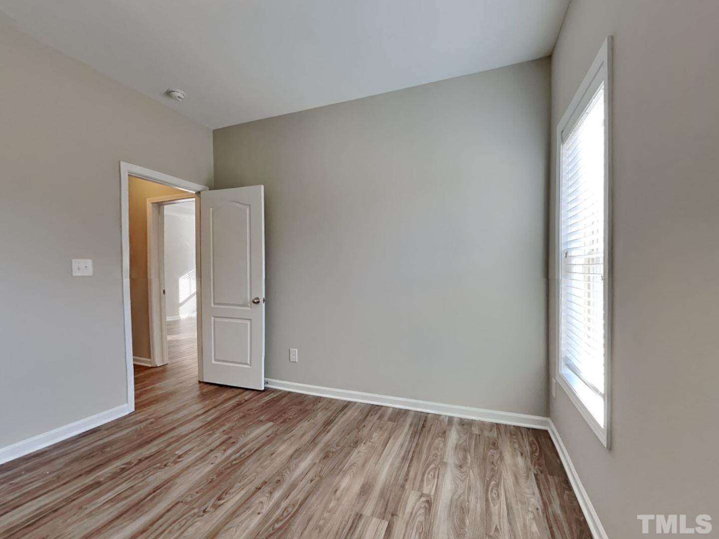 180 Crane Way Bunnlevel, NC 28323 - Photo 13 of 18 an empty room with wooden floor and windows