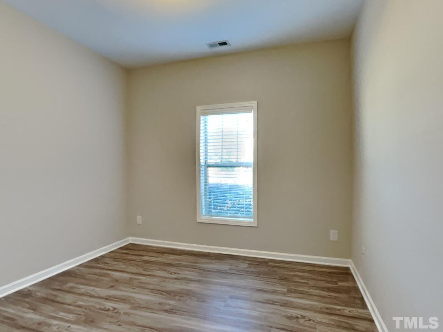 180 Crane Way Bunnlevel, NC 28323 - Photo 14 of 18 an empty room with wooden floor and windows