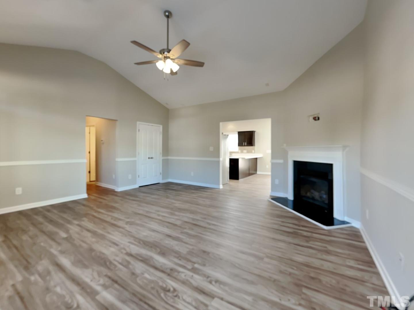 180 Crane Way Bunnlevel, NC 28323 - Photo 3 of 18 a view of an empty room with window fireplace and wooden floor