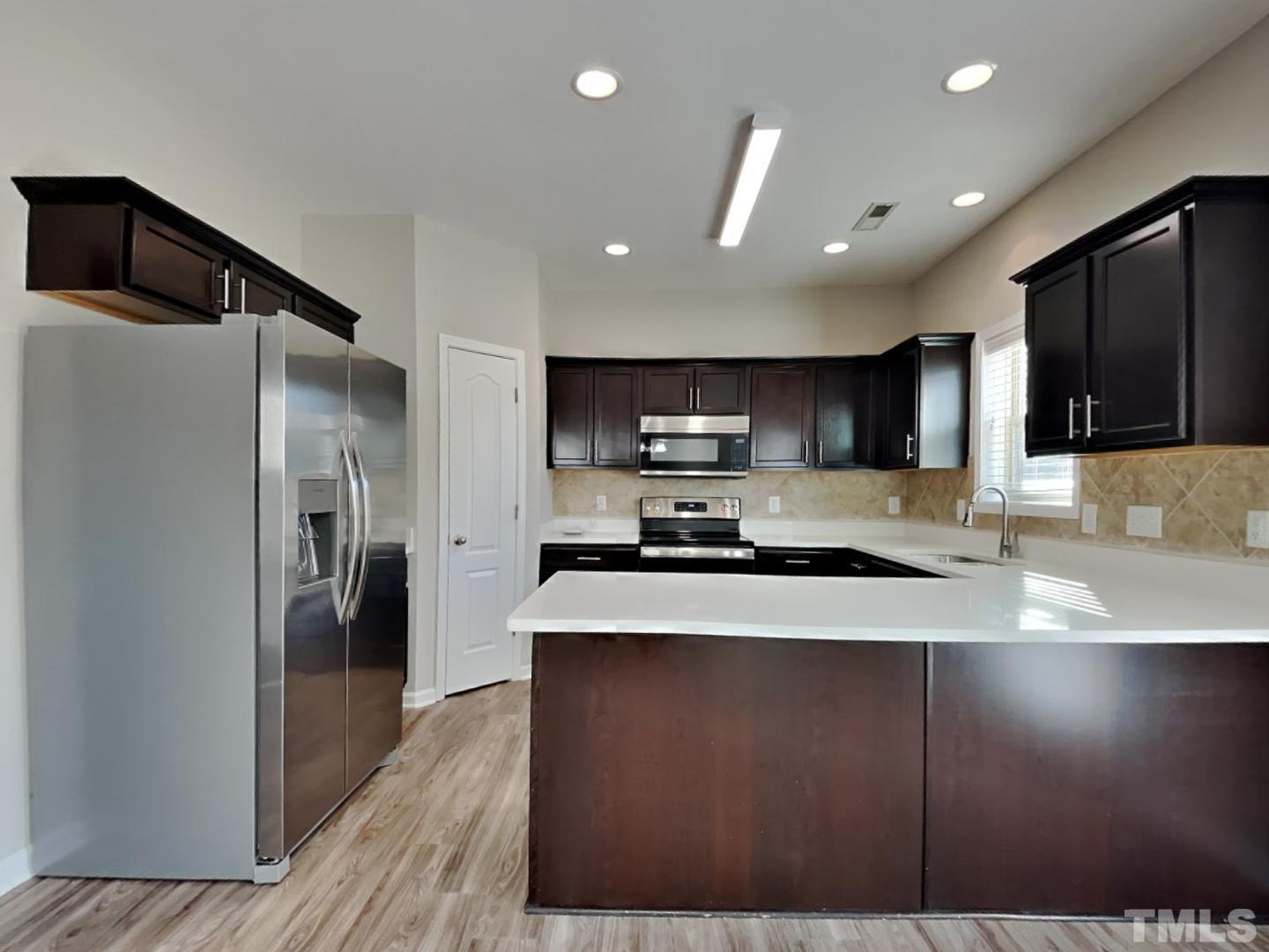 180 Crane Way Bunnlevel, NC 28323 - Photo 5 of 18 a kitchen with stainless steel appliances granite countertop a refrigerator a sink a stove and cabinets