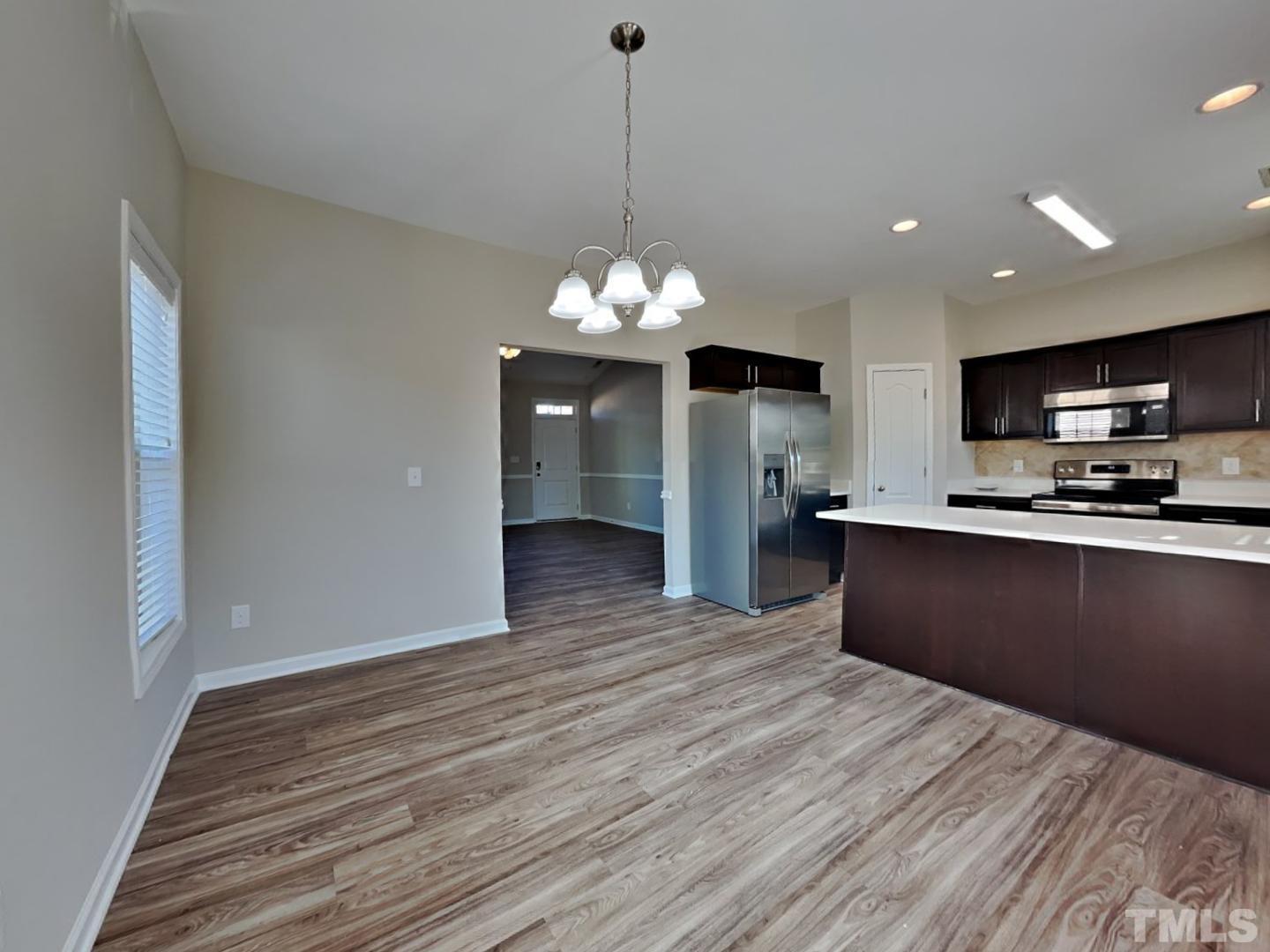 180 Crane Way Bunnlevel, NC 28323 - Photo 6 of 18 a kitchen with granite countertop stainless steel appliances and wooden floor