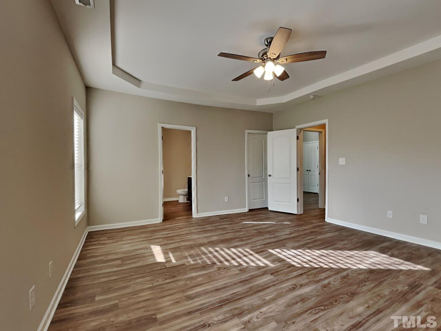 180 Crane Way Bunnlevel, NC 28323 - Photo 7 of 18 a view of an empty room with wooden floor and a ceiling fan