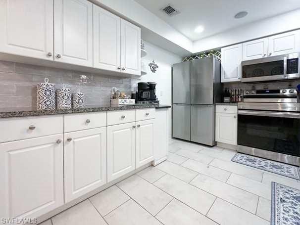 3790 35th Avenue Northeast Naples, FL 34120 - Photo 16 of 27 a kitchen with stainless steel appliances granite countertop a refrigerator a stove a sink and white cabinets