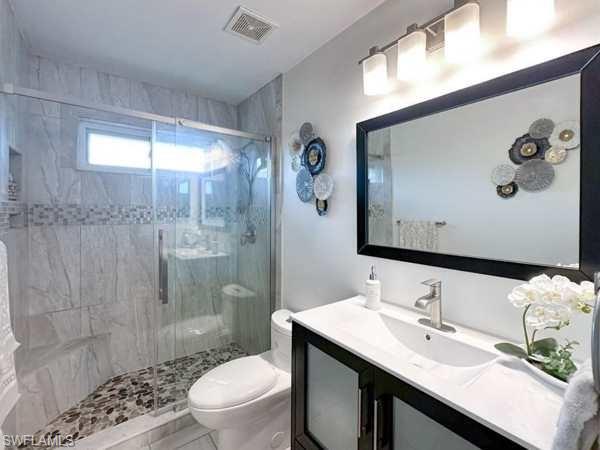 3790 35th Avenue Northeast Naples, FL 34120 - Photo 23 of 27 a bathroom with a granite countertop sink a toilet a mirror and shower