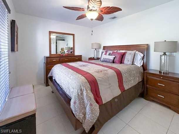 3790 35th Avenue Northeast Naples, FL 34120 - Photo 24 of 27 a spacious bedroom with a bed and a chandelier